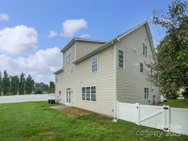 a view of backyard with barbeque grill and a large tree