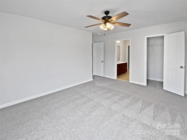 a view of an empty room with a chandelier fan