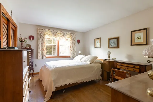 a view of a bedroom with wooden floor and bathroom