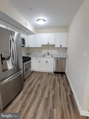 a kitchen with granite countertop a refrigerator sink and stove