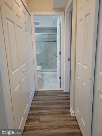 a view of a hallway with wooden floor and staircase