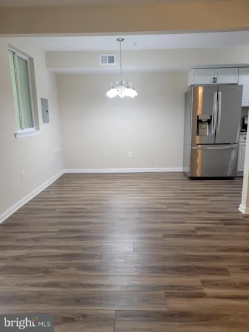 a view of a kitchen with wooden cabinet and stainless steel appliances