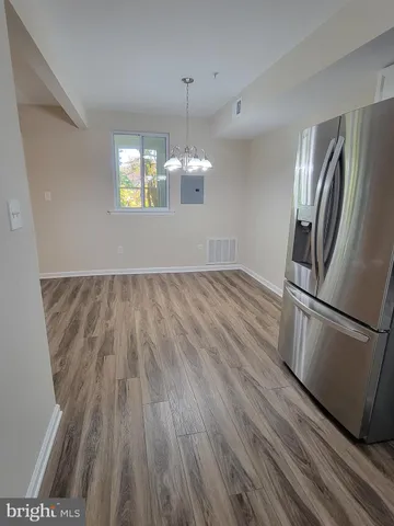 a view of a kitchen with a wooden floor and stainless steel appliances