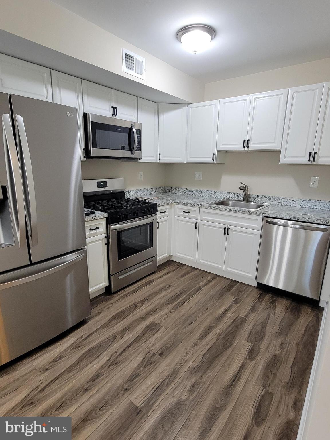411 North Stiles Avenue, Unit E3 Maple Shade, NJ 08052 - Photo 9 of 14 a kitchen with granite countertop a refrigerator stove top oven and sink