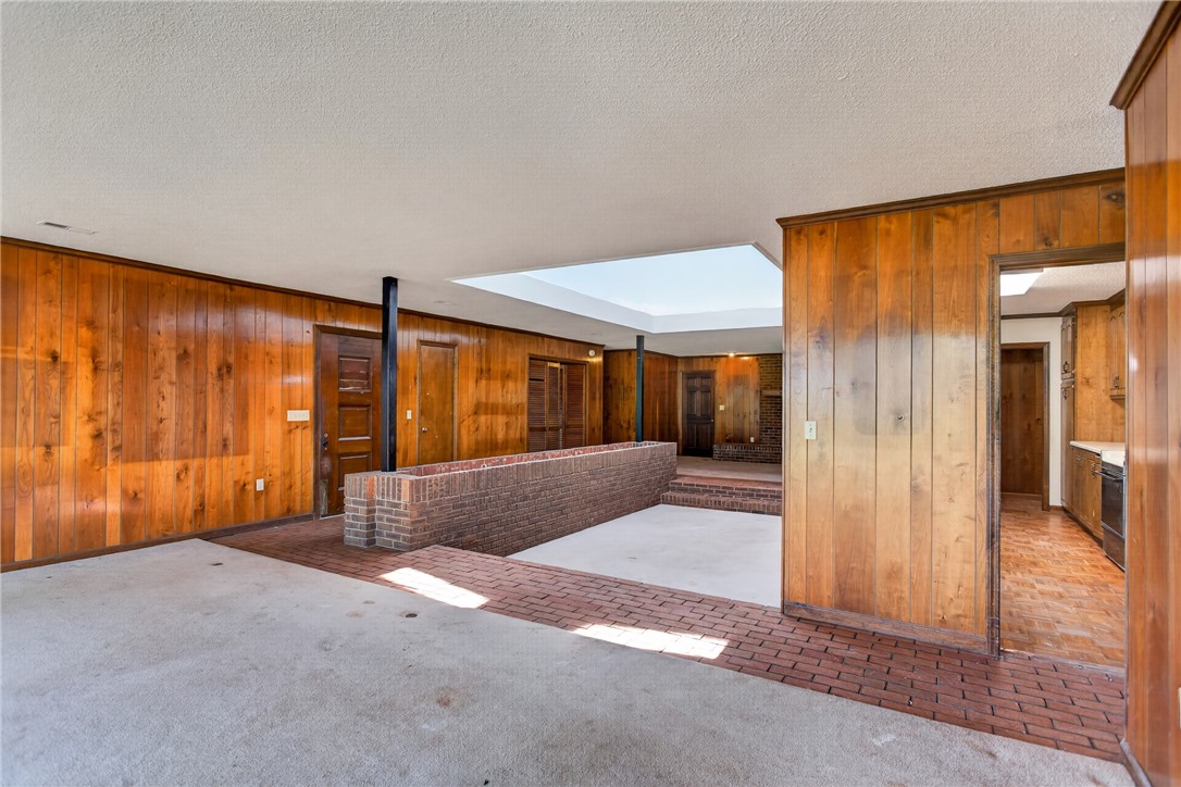 1412 Simpson Road Pendleton, SC 29670 - Photo 5 of 48 A spacious, open-concept interior features warm wood paneling and a large central skylight, illuminating the versatile living areas.