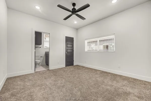 an empty room with closet and a ceiling fan