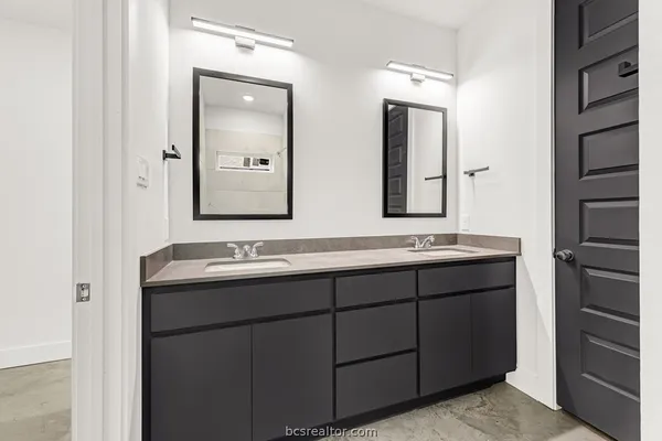 a bathroom with a double vanity sink and mirror