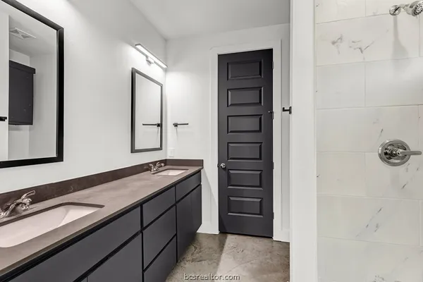 a bathroom with a double vanity sink and mirror