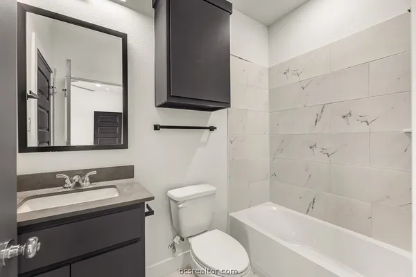 a bathroom with a sink toilet a mirror and shower