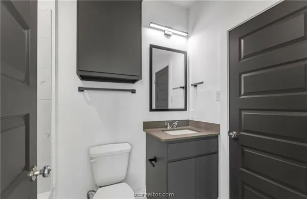 a bathroom with a toilet a sink and mirror