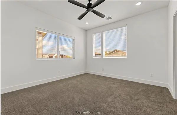 an empty room with a window and a ceiling fan