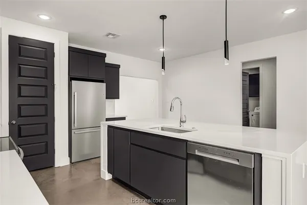 a kitchen with a sink stainless steel appliances and cabinets
