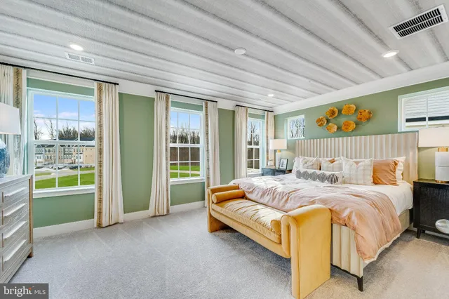 a bed sitting in a spacious bedroom next to a window