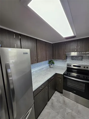 a kitchen with stainless steel appliances a refrigerator a sink a stove and cabinets