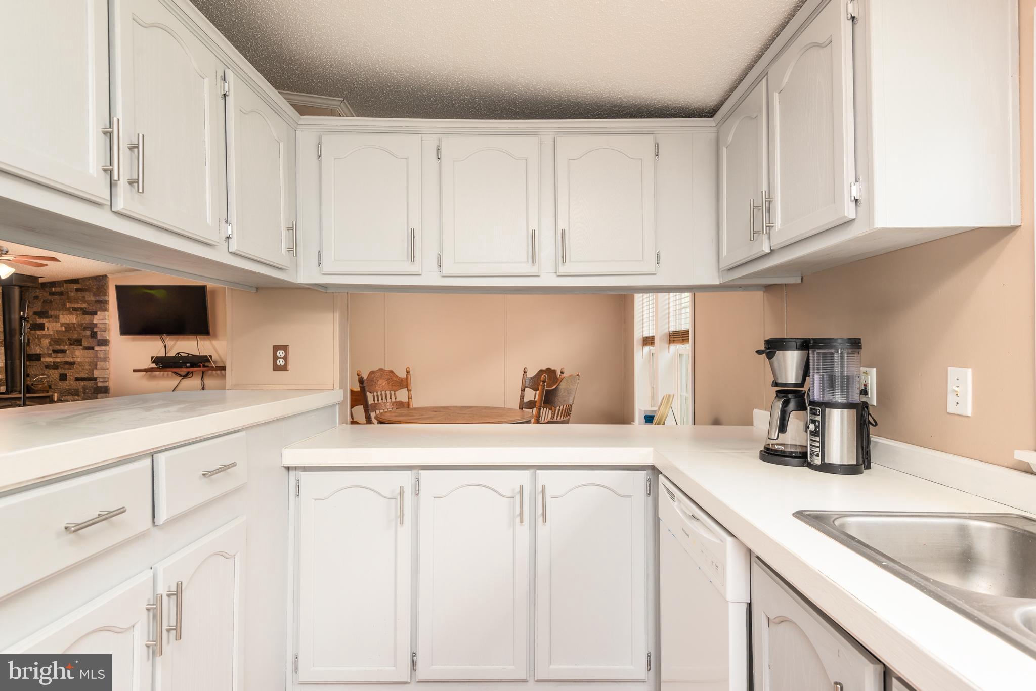 146 Bear Pond Road Marydel, MD 21649 - Photo 11 of 29 a kitchen with white cabinets and a sink