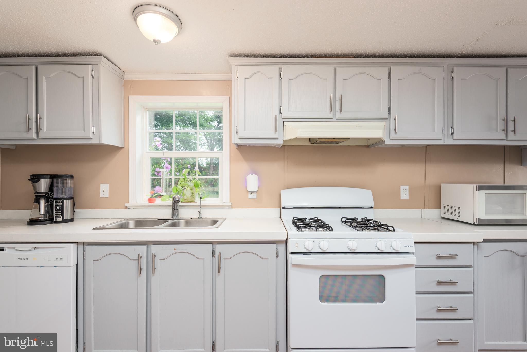 146 Bear Pond Road Marydel, MD 21649 - Photo 10 of 29 a kitchen with granite countertop white cabinets and white appliances