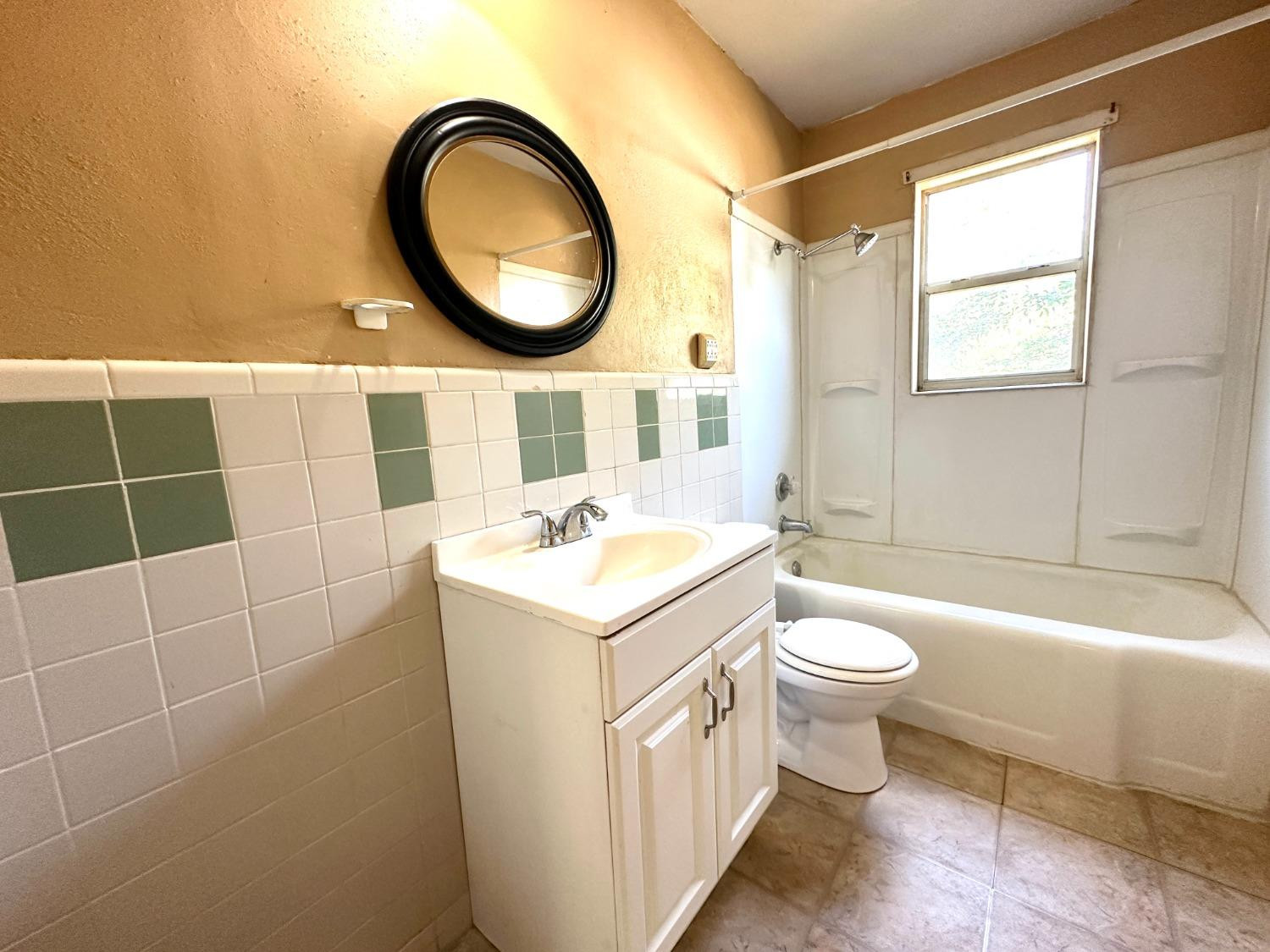 3004 43rd Street Lubbock, TX 79413 - Photo 6 of 8 a bathroom with a sink a toilet and a mirror