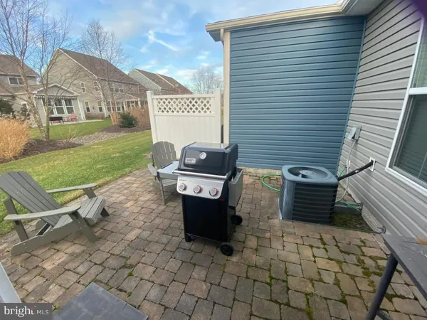 a view of a green field with sitting area in front of the house