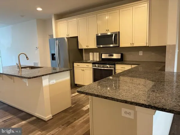 a kitchen with stainless steel appliances granite countertop a sink a stove and a refrigerator