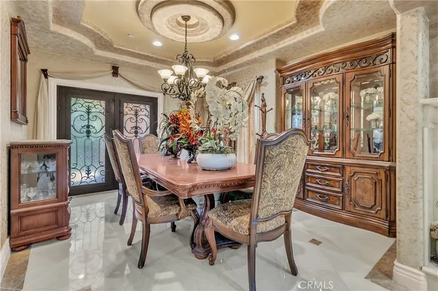 a view of a dining room with furniture a chandelier and wooden floor