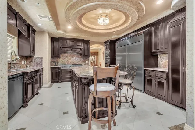 a dining area with a table chairs and a kitchen view