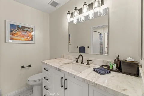 a bathroom with a sink a toilet and a mirror
