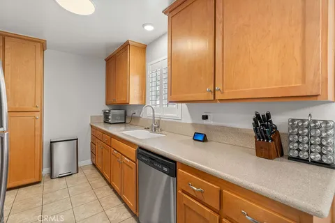 a kitchen with stainless steel appliances a sink dishwasher refrigerator and cabinets