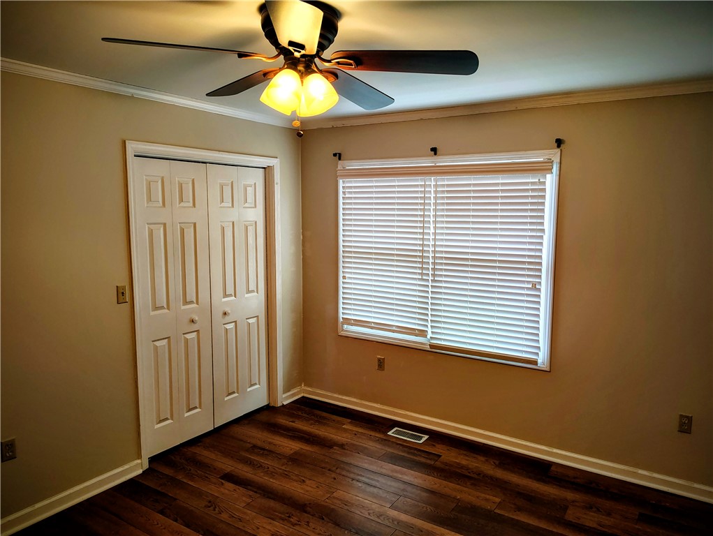 This cozy bedroom offers a warm ambiance with rich hardwood flooring and classic details.
