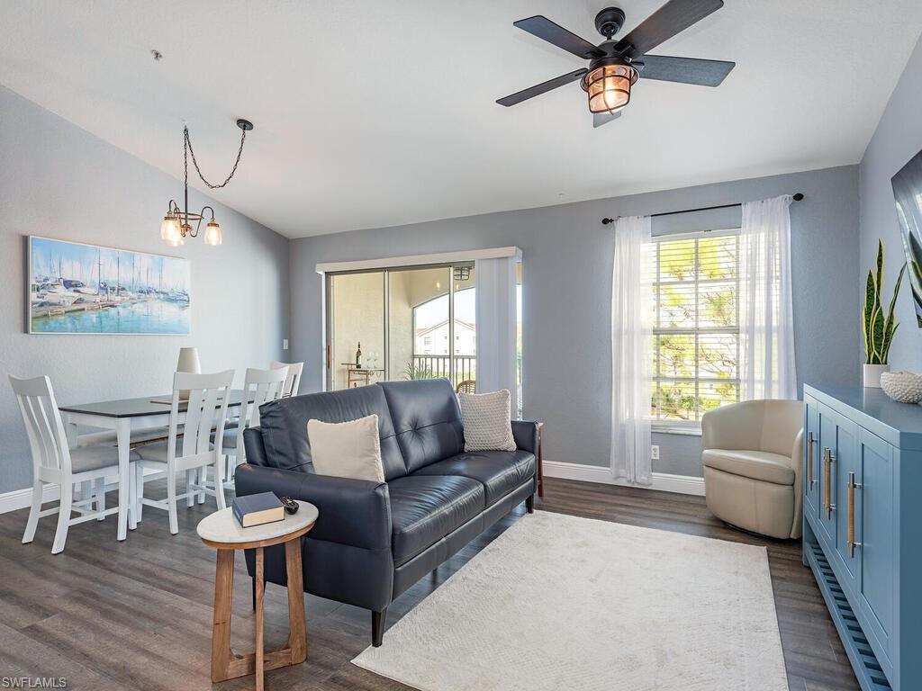 a living room with furniture a ceiling fan and a window