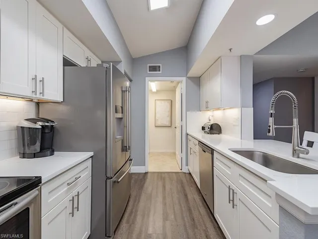 a bedroom with a bed and a flat tv screen on the dresser