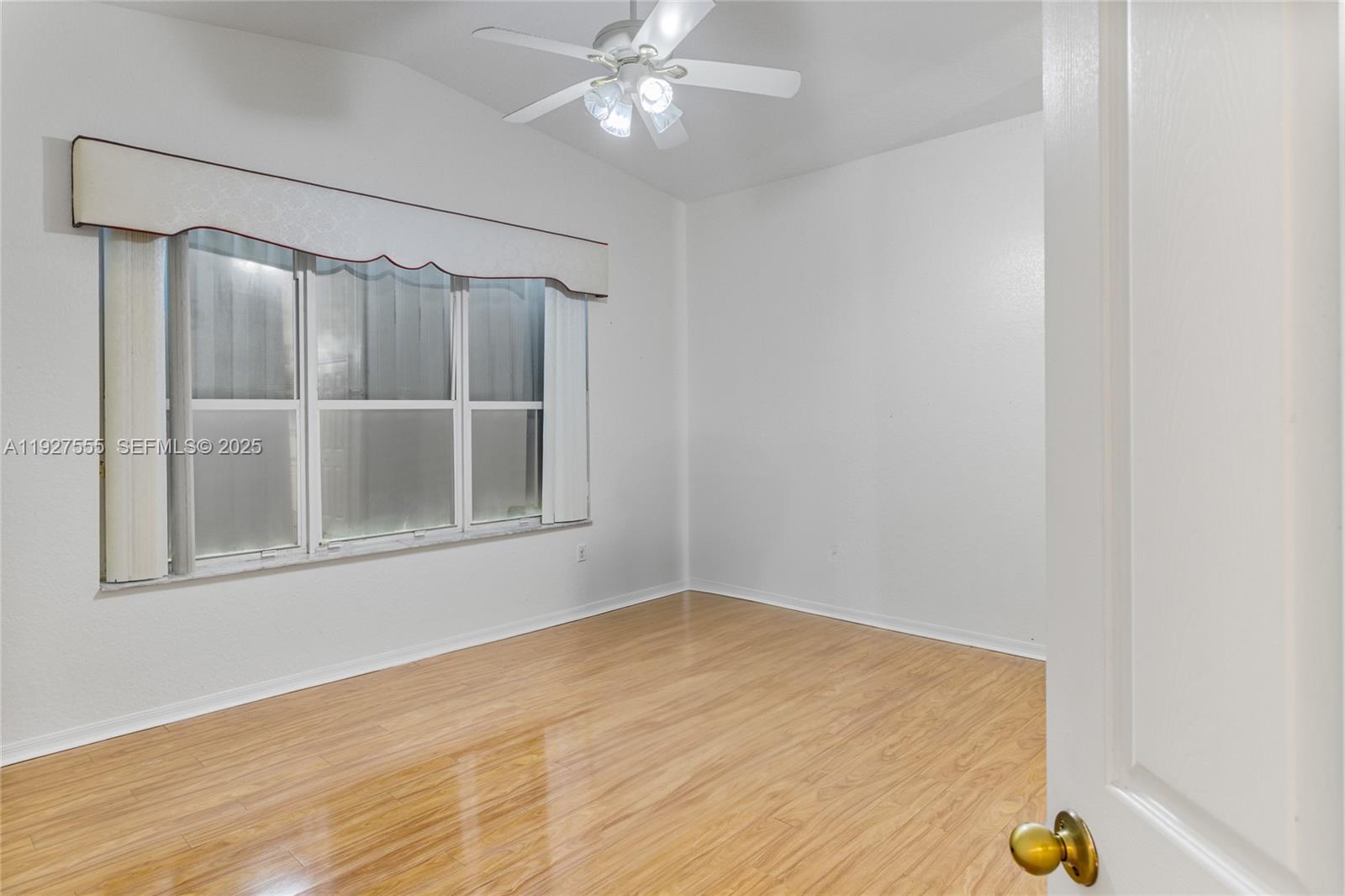 13148 Southwest 23rd Street Miramar, FL 33027 - Photo 11 of 24 a view of an empty room with wooden floor and a window