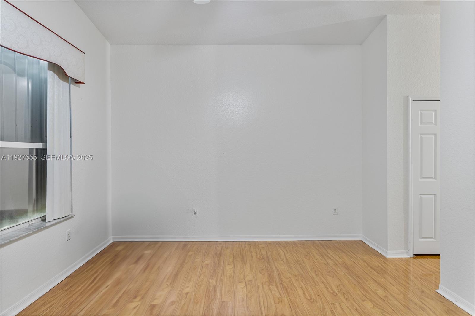 13148 Southwest 23rd Street Miramar, FL 33027 - Photo 12 of 24 a view of an empty room with wooden floor and a window