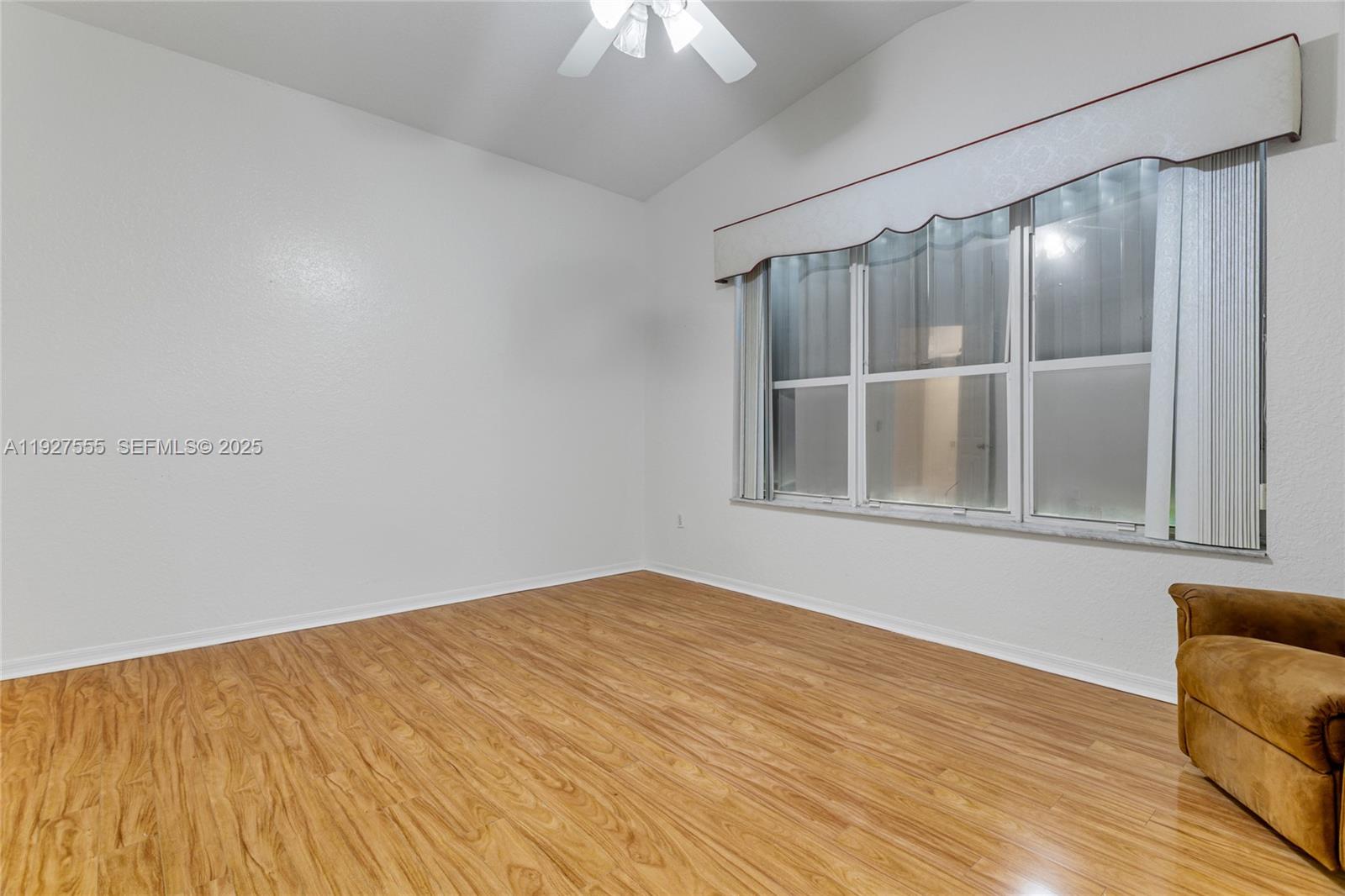 13148 Southwest 23rd Street Miramar, FL 33027 - Photo 14 of 24 a view of an empty room with wooden floor and a window