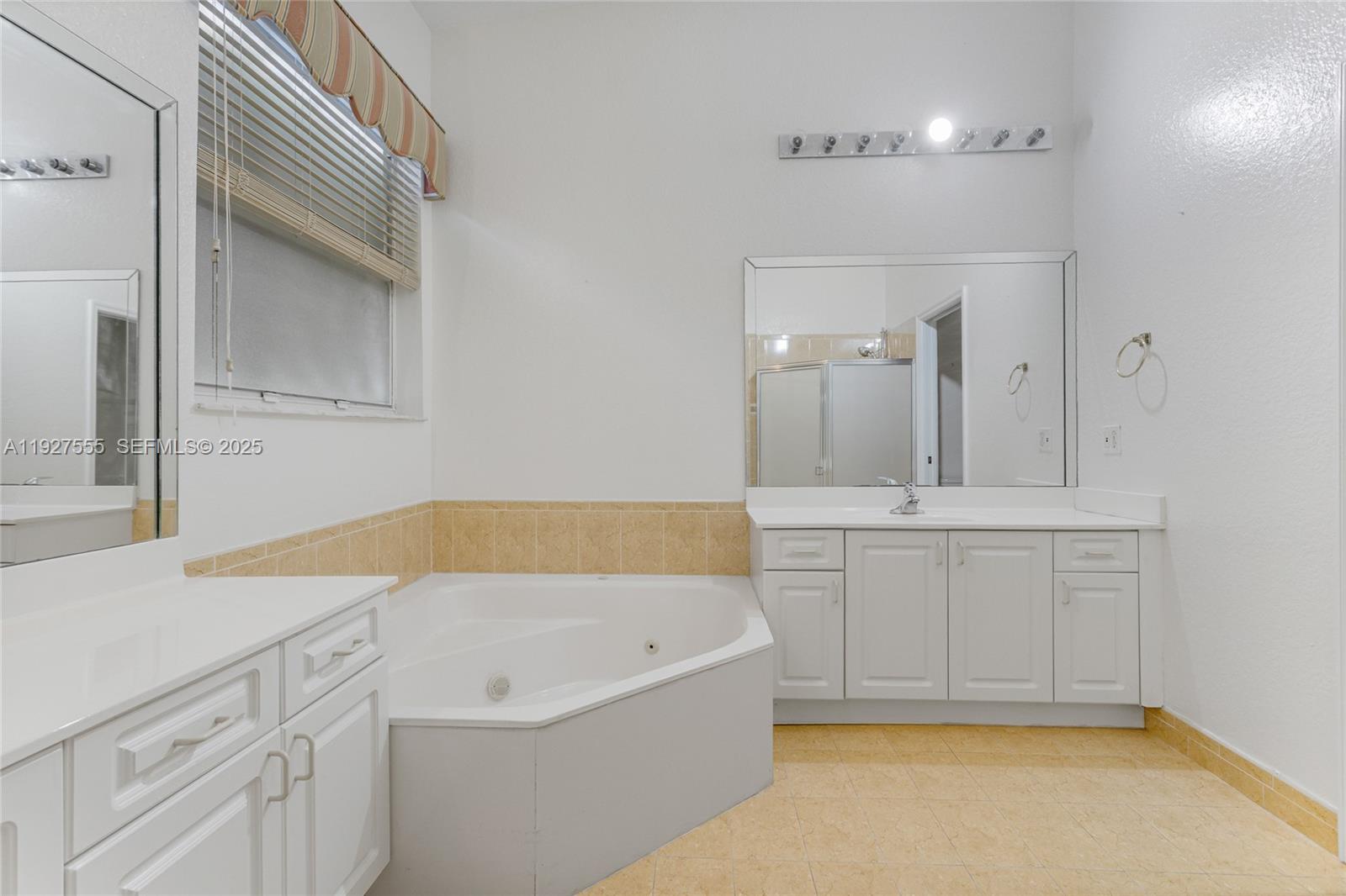 13148 Southwest 23rd Street Miramar, FL 33027 - Photo 15 of 24 a bathroom with a tub sink and mirror