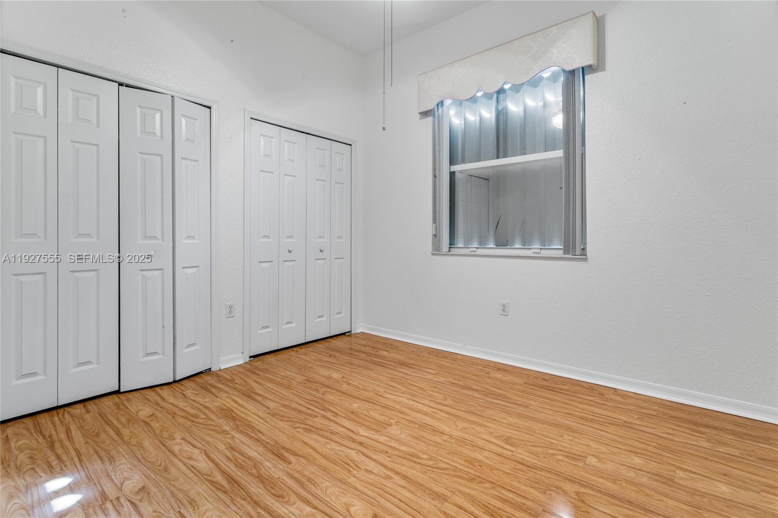 13148 Southwest 23rd Street Miramar, FL 33027 - Photo 20 of 24 a view of an empty room with wooden floor
