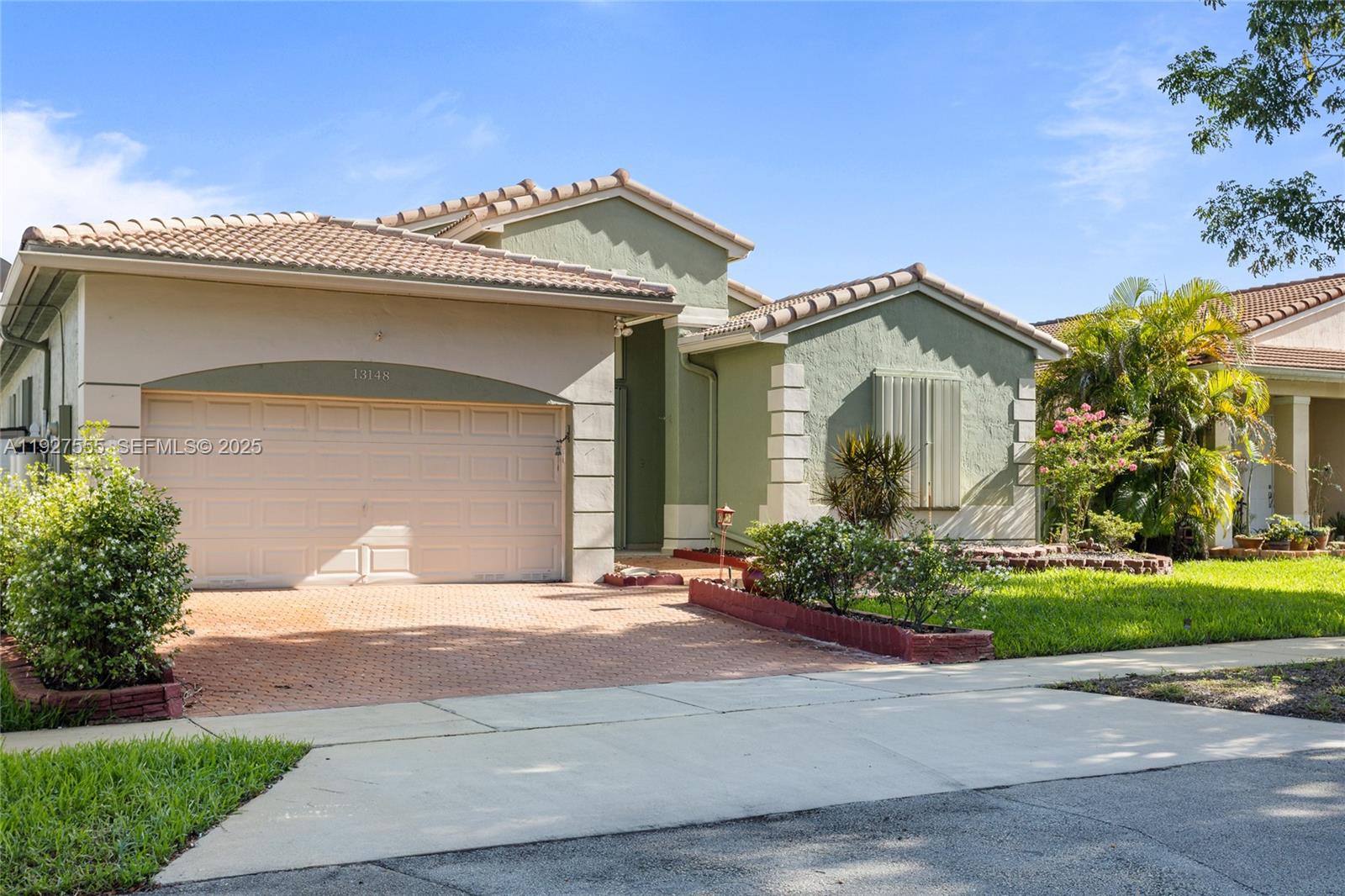 13148 Southwest 23rd Street Miramar, FL 33027 - Photo 2 of 24 a front view of a house with garden