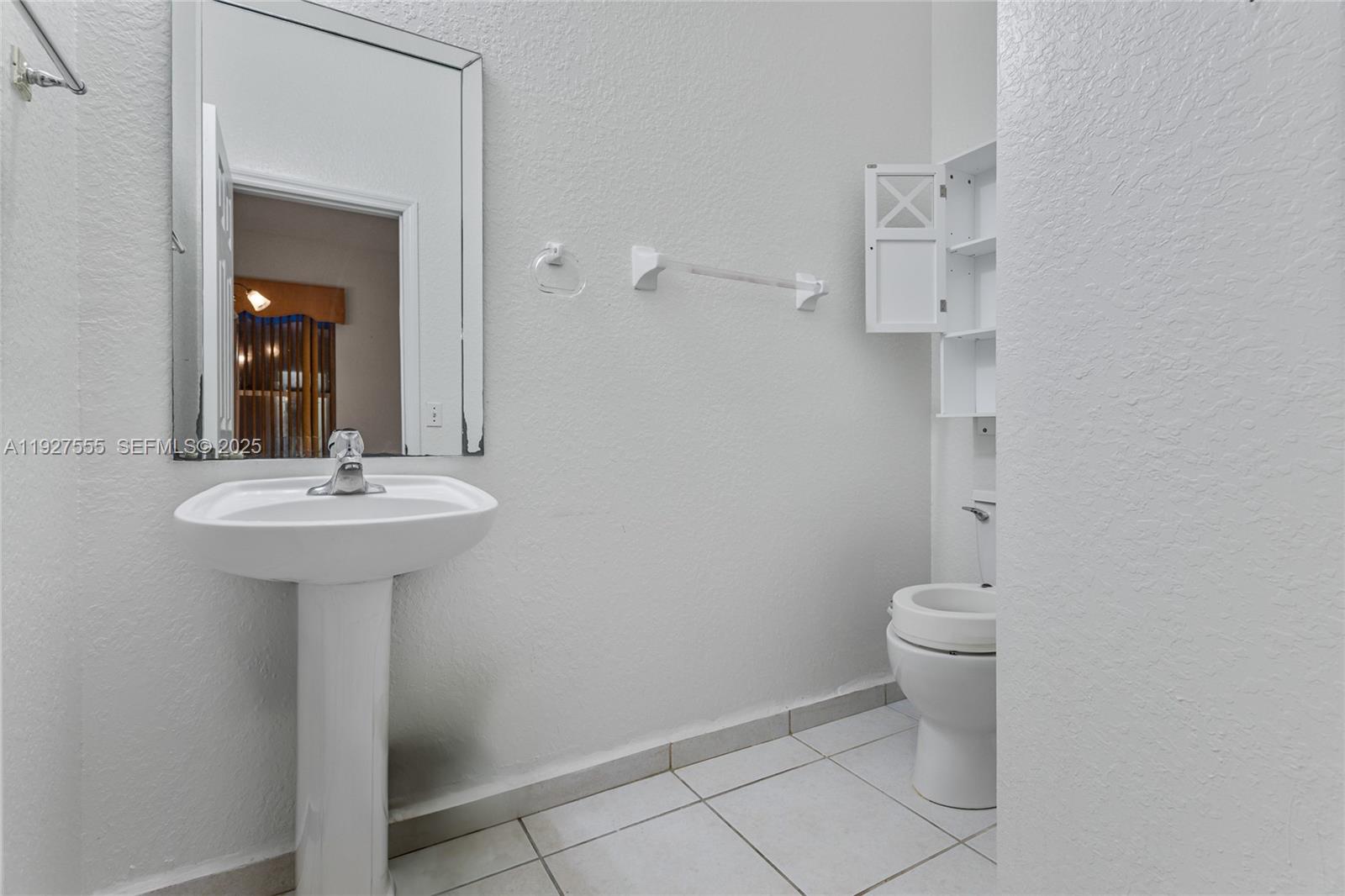 13148 Southwest 23rd Street Miramar, FL 33027 - Photo 21 of 24 a bathroom with a sink toilet and a mirror