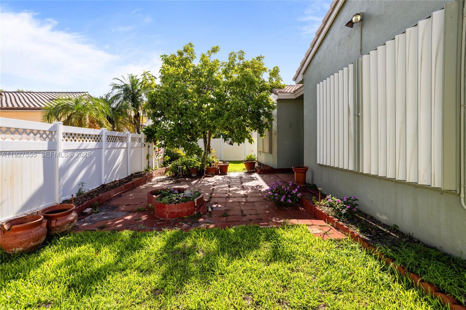 13148 Southwest 23rd Street Miramar, FL 33027 - Photo 23 of 24 a view of a backyard with plants and a bench