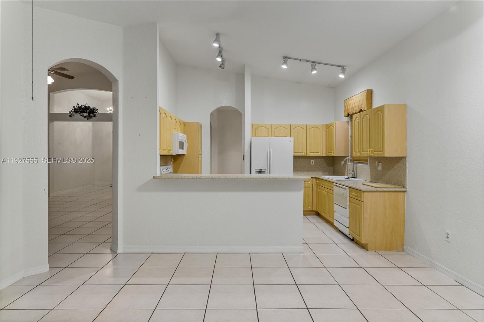 13148 Southwest 23rd Street Miramar, FL 33027 - Photo 9 of 24 a kitchen with a sink and refrigerator