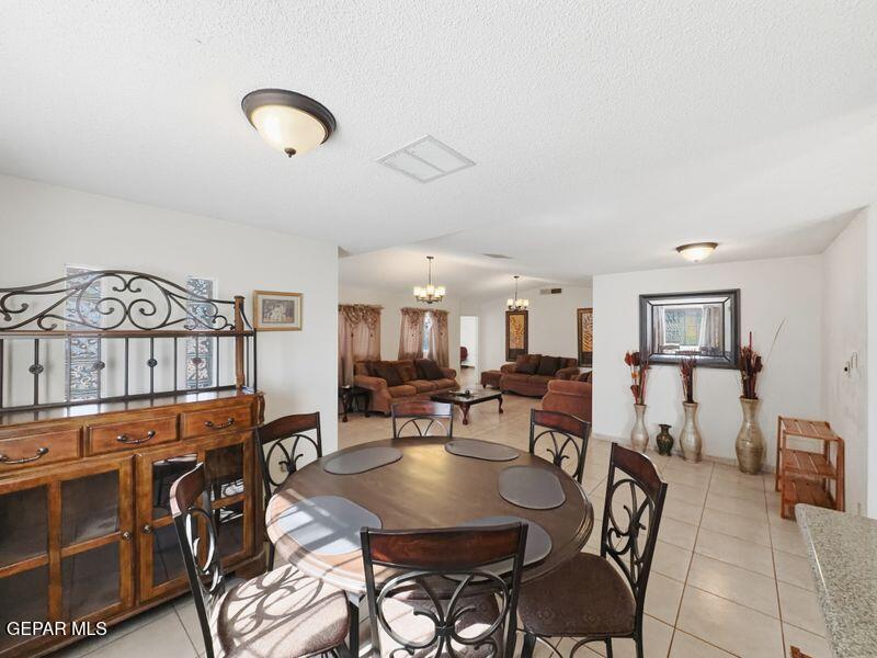 445 Suzi Way Socorro, TX 79927 - Photo 11 of 35 a living room with furniture a rug and a chandelier