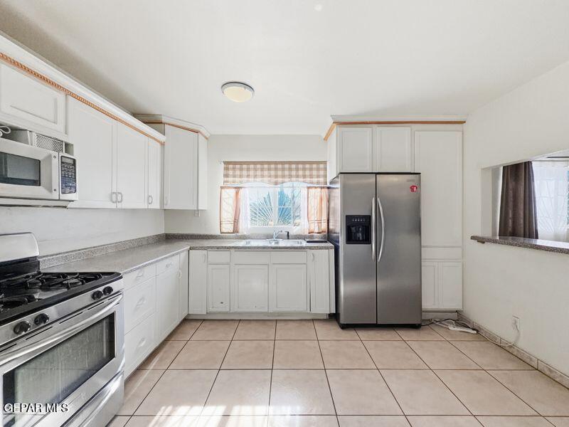 445 Suzi Way Socorro, TX 79927 - Photo 14 of 35 a kitchen with a stove top oven and refrigerator