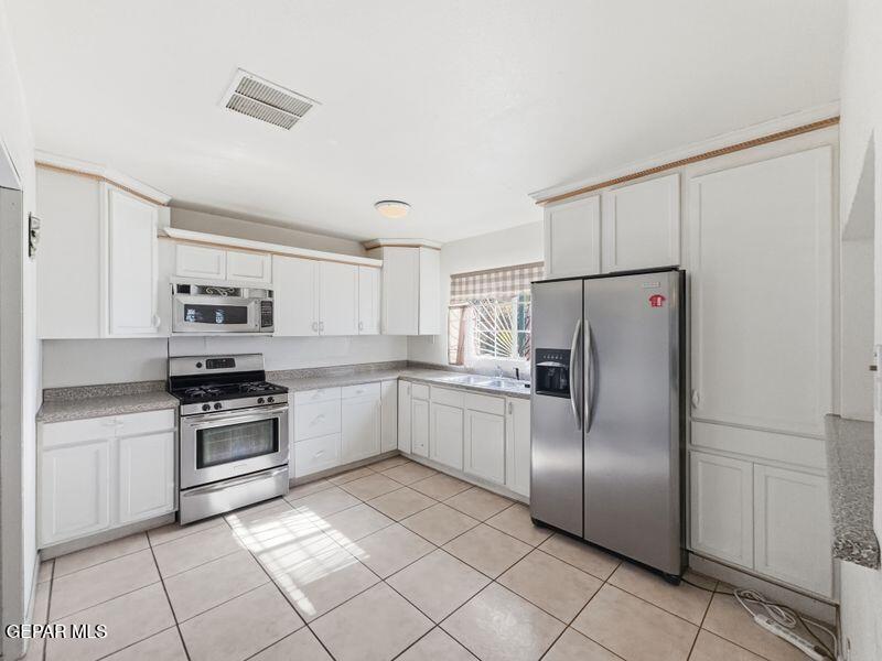 445 Suzi Way Socorro, TX 79927 - Photo 15 of 35 a kitchen with stainless steel appliances granite countertop a refrigerator sink and stove