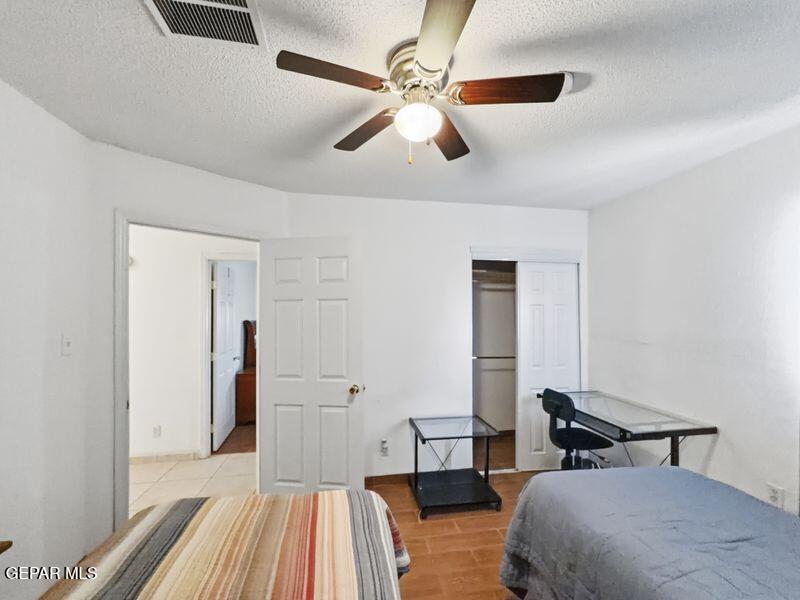 445 Suzi Way Socorro, TX 79927 - Photo 23 of 35 a bedroom with a bed and a chandelier