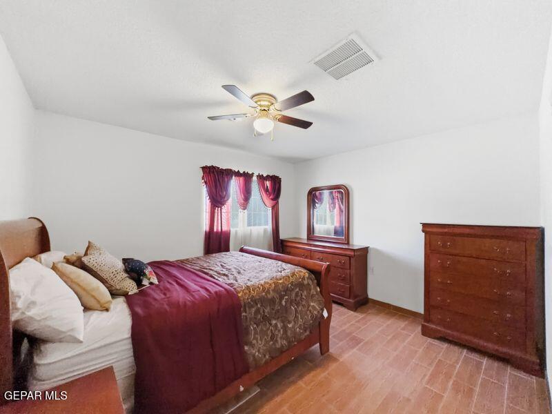 445 Suzi Way Socorro, TX 79927 - Photo 27 of 35 a bedroom with a bed and a dresser with wooden floor