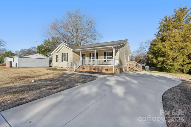 a front view of a house with a yard and trees
