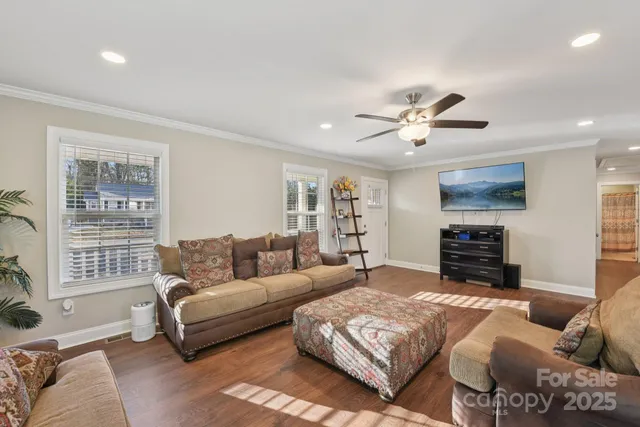 a living room with furniture ceiling fan and a window