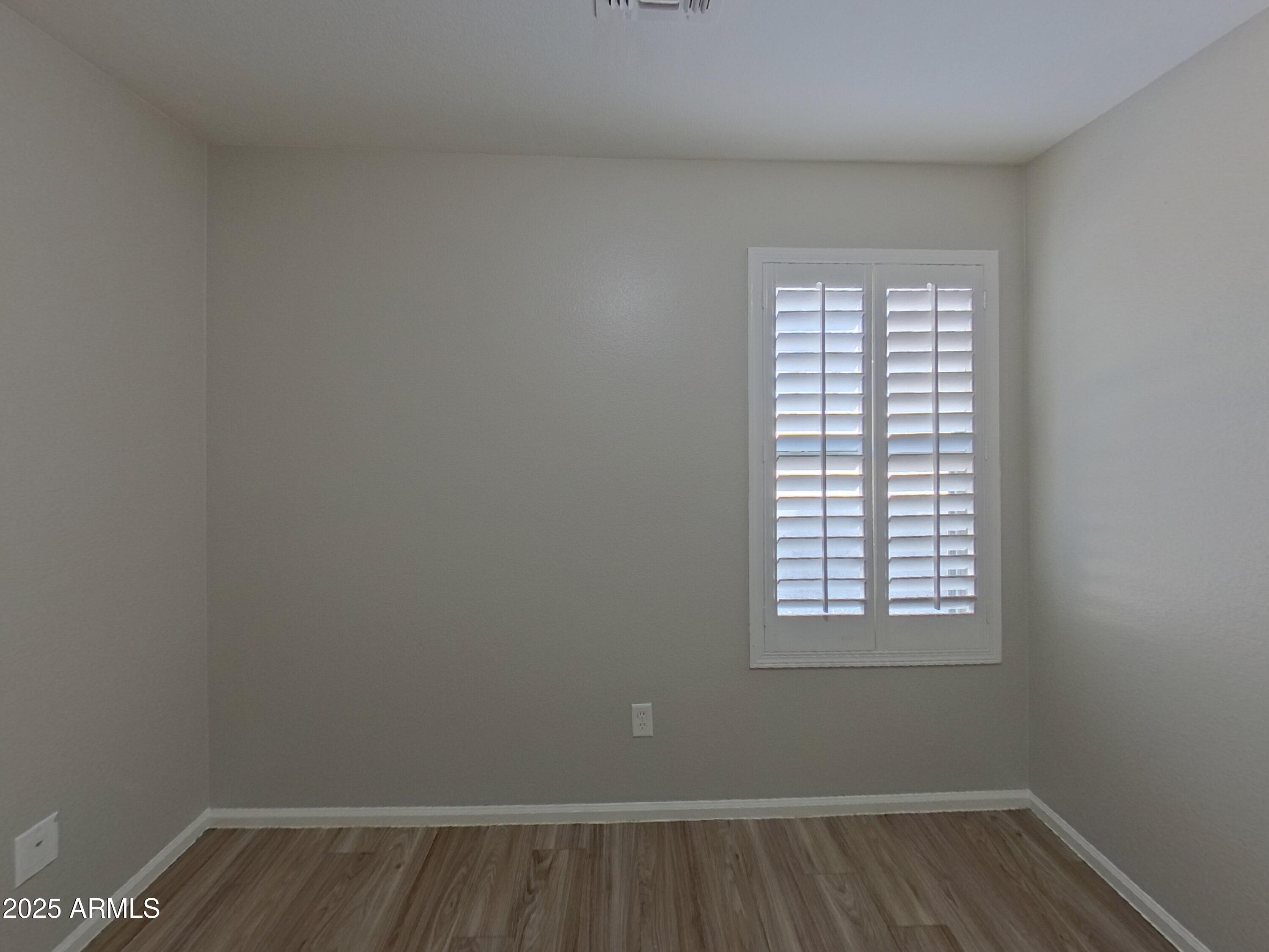 42396 Colby Drive Maricopa, AZ 85138 - Photo 11 of 17 a view of an empty room with wooden floor and a window