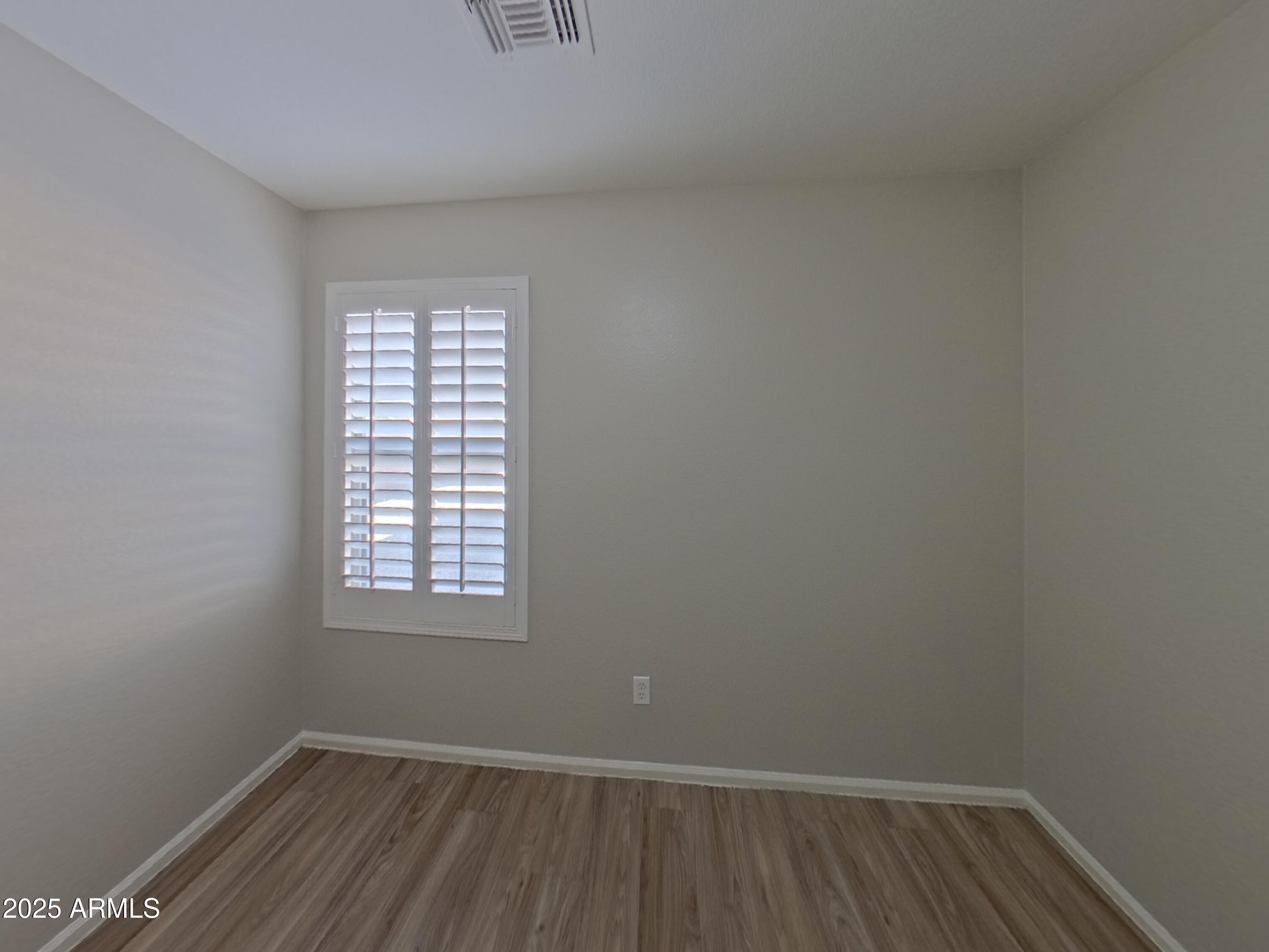 42396 Colby Drive Maricopa, AZ 85138 - Photo 13 of 17 an empty room with wooden floor and windows