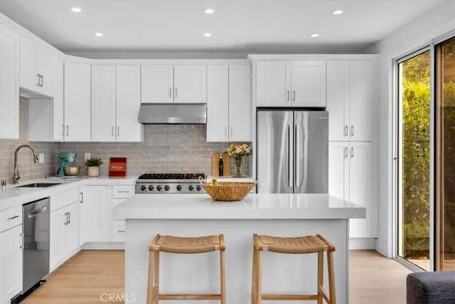 a kitchen with granite countertop white cabinets and stainless steel appliances