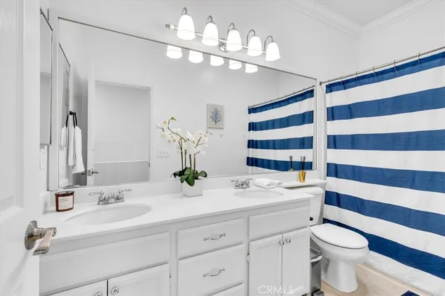 a bathroom with a double vanity sink mirror and toilet